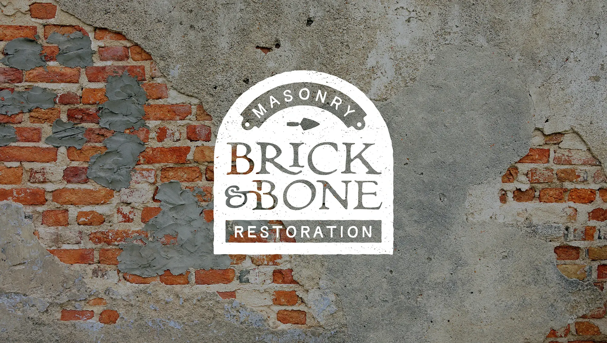 Brick and Bone Logo against a brick and plaster wall